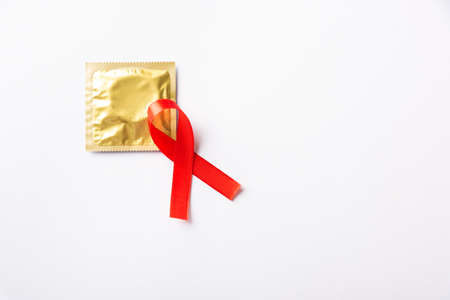 Red bow ribbon symbol HIV, AIDS cancer awareness and condom with shadows, studio shot isolated on white background, Healthcare medicine sexually concept, World AIDS Dayの写真素材