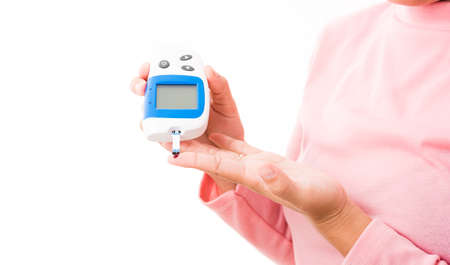 Closeup hands woman measur glucose test level check with blood on finger by glucometer she monitor...