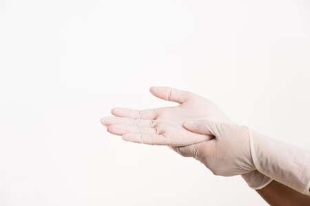 Woman wearing and putting hand to white rubber latex surgical medical glove for doctor, studio shot...