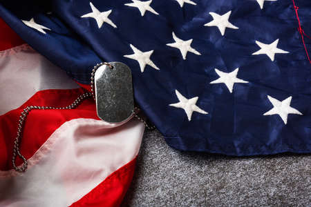 America United States flag and chain dog tags, military symbolizing, studio shot on concrete board background, US Veterans or Independence day conceptの写真素材