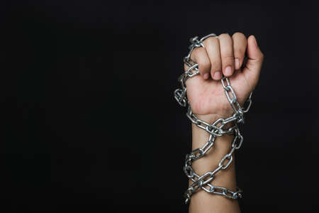 Woman chained on hand on black background, Human trafficking and abuse, International Human Rights dayの写真素材