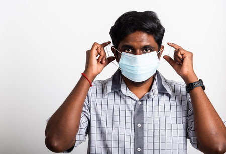 Asian happy portrait young black man wearing face mask protective from virus coronavirus epidemic or air pollution looking camera, studio shot isolated on white background, stop COVID-19 conceptの写真素材