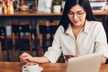 Lifestyle freelance woman he using a mobile smartphone to socialize media online in coffee shopの写真素材