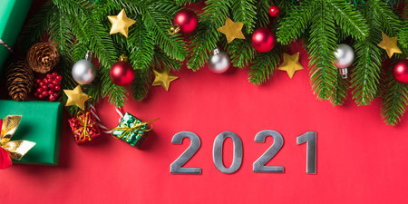 Christmas background presents greeting card with top view overhead green fir tree branches and decoration gift box, Xmas holiday celebration season on red table background with copy spaceの写真素材