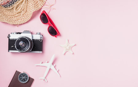 Top view flat lay mockup of retro camera films, airplane, hat, sunglasses, starfish beach traveler accessories on pink background with copy space, Business trip, and vacation summer travel conceptの写真素材