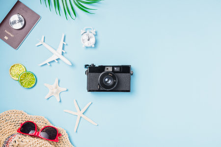 Flat lay top view mockup retro camera films, airplane, starfish, shells, hat traveler tropical accessories on a blue background with copy space, Business trip, and vacation summer travel conceptの写真素材
