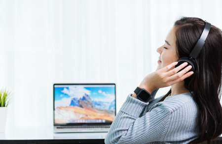 Work from home, Asian young business woman feeling relaxing listening to music with headphones on...
