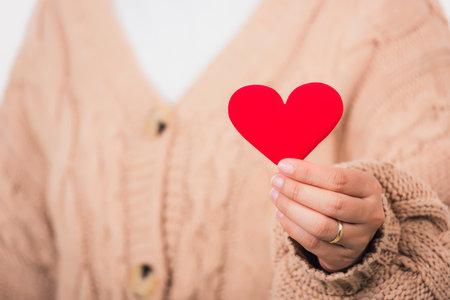 Love Valentine's Day. Female beauty hands holding modern a red heart isolated on white background, giving help donation medical healthcare happy holiday background conceptの写真素材