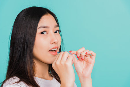 Female hold teeth retaining tools after removable braces, Portrait young Asian beautiful woman...