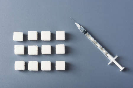White sugar cube sweet food ingredient geometry pattern and syringe tube, studio shot isolated on a gray background, Minimal health high blood risk of diabetes and calorie intake conceptの写真素材
