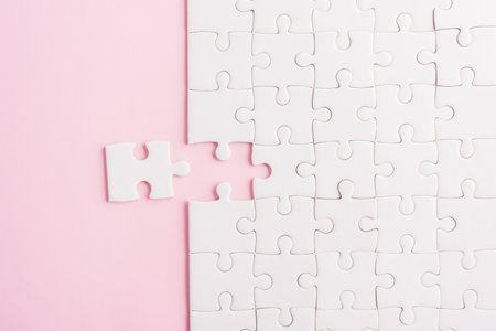 Top view flat lay of paper plain white jigsaw puzzle game texture last pieces for solve and place, studio shot on a pink background, quiz calculation conceptの写真素材