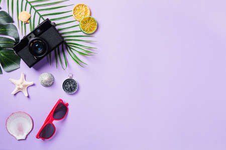 Top view flat lay mockup of camera films, shells, leaves, starfish beach traveler accessories on a purple background with copy space, Business trip, and vacation summer travel conceptの写真素材