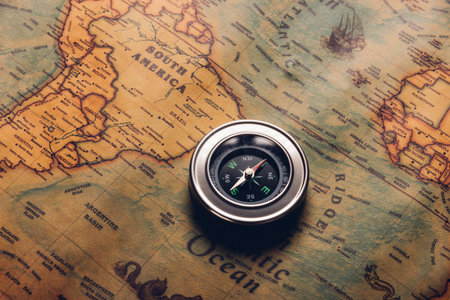 Old compass discovery on vintage paper antique world map background, Retro style cartography travel geography navigation, Pirate navigate the geography, Columbus Day conceptの写真素材