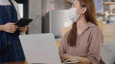 Asian young beautiful businesswoman smile using laptop computer online at coffee shop, Hospitable...