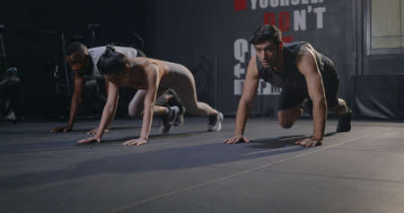 Three group muscular young Caucasian man and Asian woman doing laughing exercise workout physique...