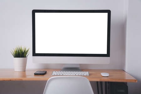Computer monitor with white blank screen on the business desk with wireless mouse, keyboard at home...