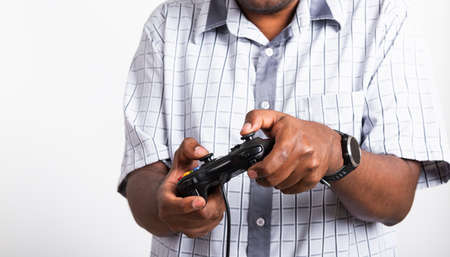 Asian happy portrait young black man funny use hand playing video game pad joystick controller,...