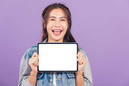 Portrait of Asian beautiful young woman confident smiling show blank screen with tablet computer,...