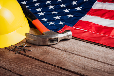 USA Labor day concept, Top view flat lay of different kinds wrenches with American flag on wood table. First Monday in September, creation of labor movement and dedicated to social of American workerの写真素材