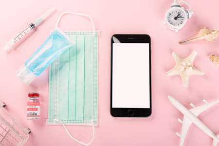 World Tourism Day, Top view model plane, medical face mask, vaccine and smartphone, Holiday accessory beach trip travel vacation studio shot isolated pink background with copy spaceの写真素材