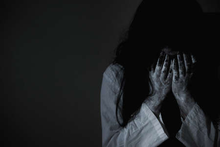 Woman ghost horror sitting crying and have her hands close the face, halloween conceptの写真素材