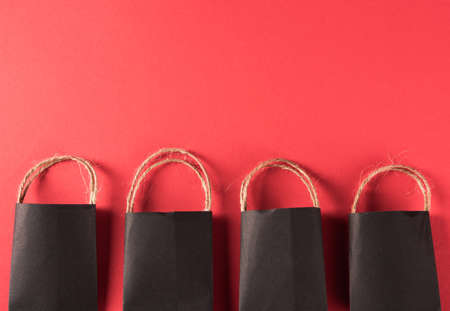 Black Friday sale shopping concept, Black shopping bags, studio shot isolated on red backgroundの写真素材