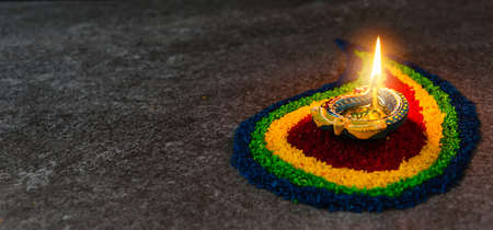 Close up clay lit light a fire already on Diya or oil lamp on concrete background, Decoration of Hinduism rangoli, Happy celebration Deepavali, or Diwali Indian festival conceptの写真素材