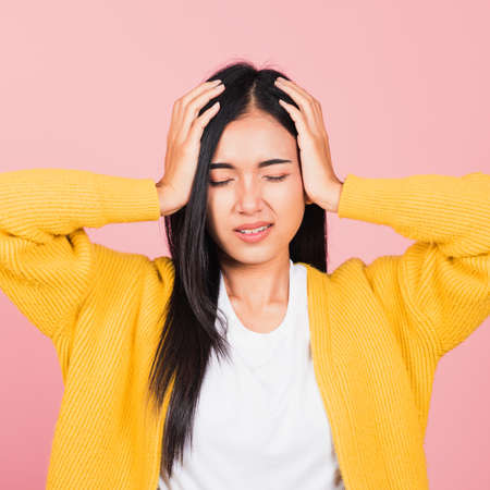 Portrait of beautiful Asian young woman sad tired strain face holding hold head by hands, female...