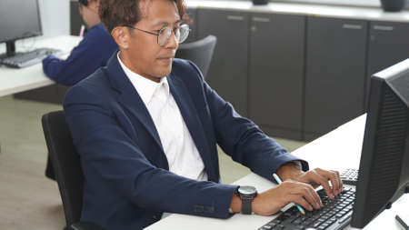 Business man using desktop PC computer she is typing keyboard, Businessman working while sitting...