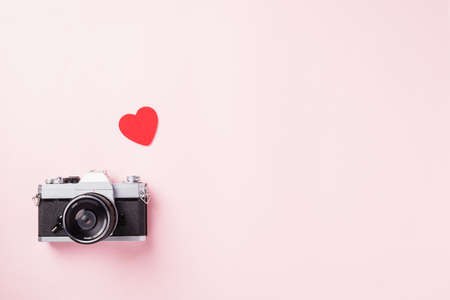 Valentines' day background. Vintage retro camera and red hearts composition greeting card love Valentines day I love photography concept on pink background with copy space. Top View from aboveの写真素材