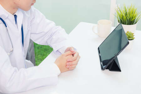 Happy Asian young doctor handsome man smile wear glasses use modern smart digital tablet computer...