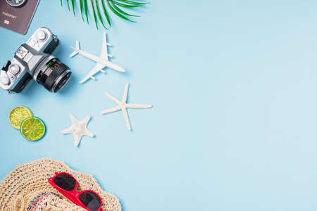 Flat lay top view mockup retro camera films, airplane, starfish, shells, hat traveler tropical accessories on a blue background with copy space, Business trip, and vacation summer travel conceptの写真素材