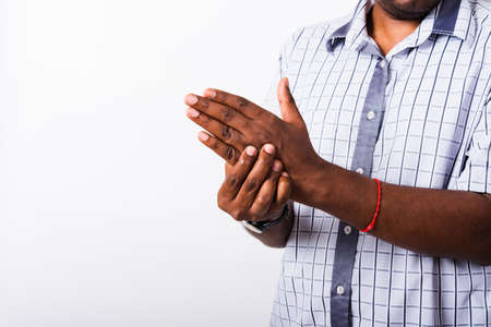 Closeup hand Asian black man holds his palm hand injury, feeling pain, studio shot isolated on white background. Health care and medical office syndrome conceptの写真素材