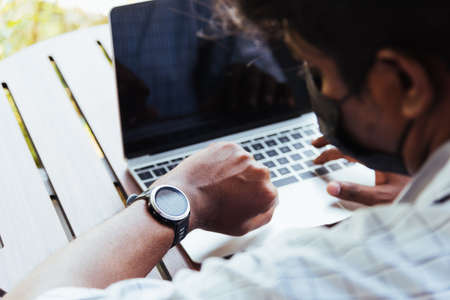 Happy Asian hand black man person working with laptop computer and looking at watch while management...