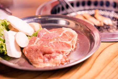 Raw pork on plate, Korean traditional style fresh pork beef belly BBQ on stove serve wood table, Japanese meat hot pot or Shabu in the restaurant, barbecue foodの写真素材