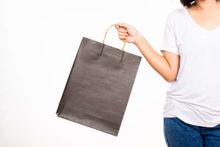 Closeup female holds in hand with black clear empty blank craft paper gift bag, women hand holding...