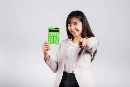 Tax day concept. Woman confident smiling holding calculator and finger point to camera, Portrait...