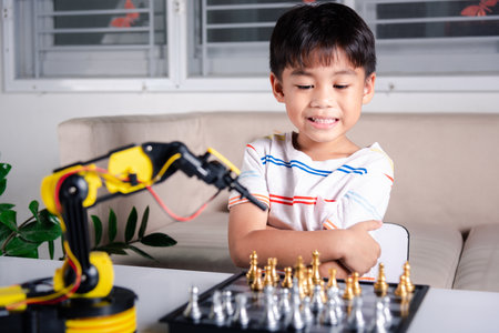 Asian little boy is playing chess with robot machine arm, STEM education E-learning, Funny children...