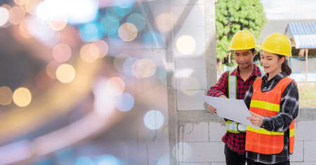 Architect and client discussing the plan with blueprint of the building at construction site. Asian engineer foreman worker man and woman working talking and checking on draw paper to checking projectの写真素材