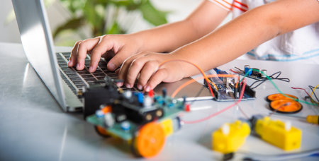 Asian kid boy learns coding and programming with laptop for Arduino robot car, Little child students...