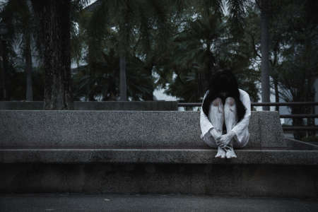 Scary woman ghost horror creepy sitting her hugging his knees, happy halloween day concept