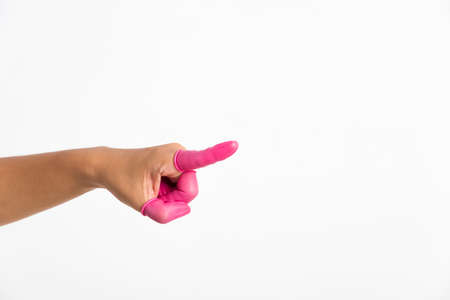 Woman hand wearing pink finger cots rubber protect help prevent fingerprints on the finger touched piece with poinging finger, studio shot isolated on white backgroundの写真素材