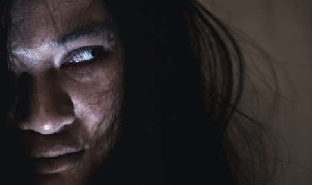 Scary ghost woman. Close up face of Asian woman ghost or zombie horror creepy scary have hair covering the face her eye at abandoned house dark tone, female make up zombie face, Happy Halloween dayの写真素材