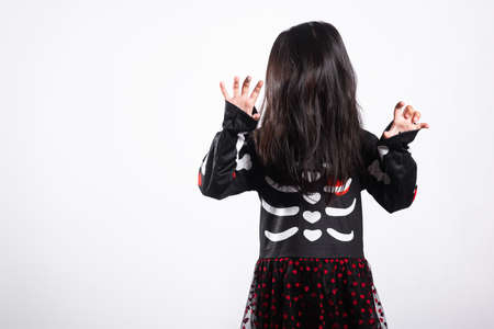 Woman child ghost or zombie horror creepy scary skeleton costume studio shot isolated on white background, Asian little kid girl with face painting and hair covering face, Happy Halloween day conceptの写真素材