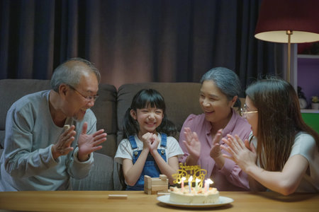 Birthday surprise. Happy Asian family grandparents and mother celebrating enjoy birthday party with...