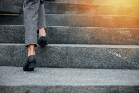 Stepping going up stairs in city, Closeup legs of businesswoman hurry up walking on stairway, rush hour to work in office a hurry in morning, foot of business woman wear black shoes step up successの写真素材