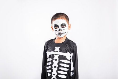 Halloween Kid. Portrait of Asian little kid boy wearing skeleton costume studio shot isolated white background, Child man horror face painting make up for scary, Happy halloween day conceptの写真素材
