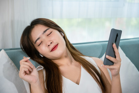 Lifestyle woman wireless earphone chill listen song and a little dancing from music application...