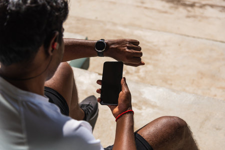 Close up Asian young athlete sport runner black man wear modern time smart watch and sync to a...