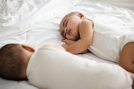 Asian two adorable twin babies boy, Happy childhood, Sleeping newborn identical boy twins on the bed on bedroom, family people infantの写真素材